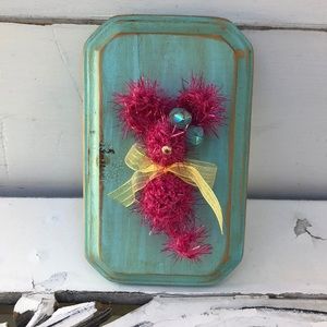 Crocheted tiny mouse on a wood plaque